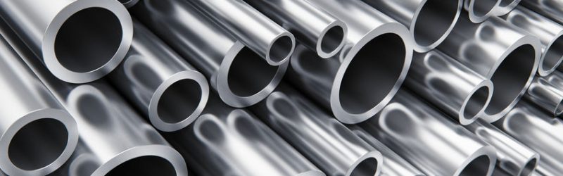 Creative abstract heavy metallurgical industry and industrial manufacturing business production concept: heap of shiny metal steel pipes with selective focus effect
